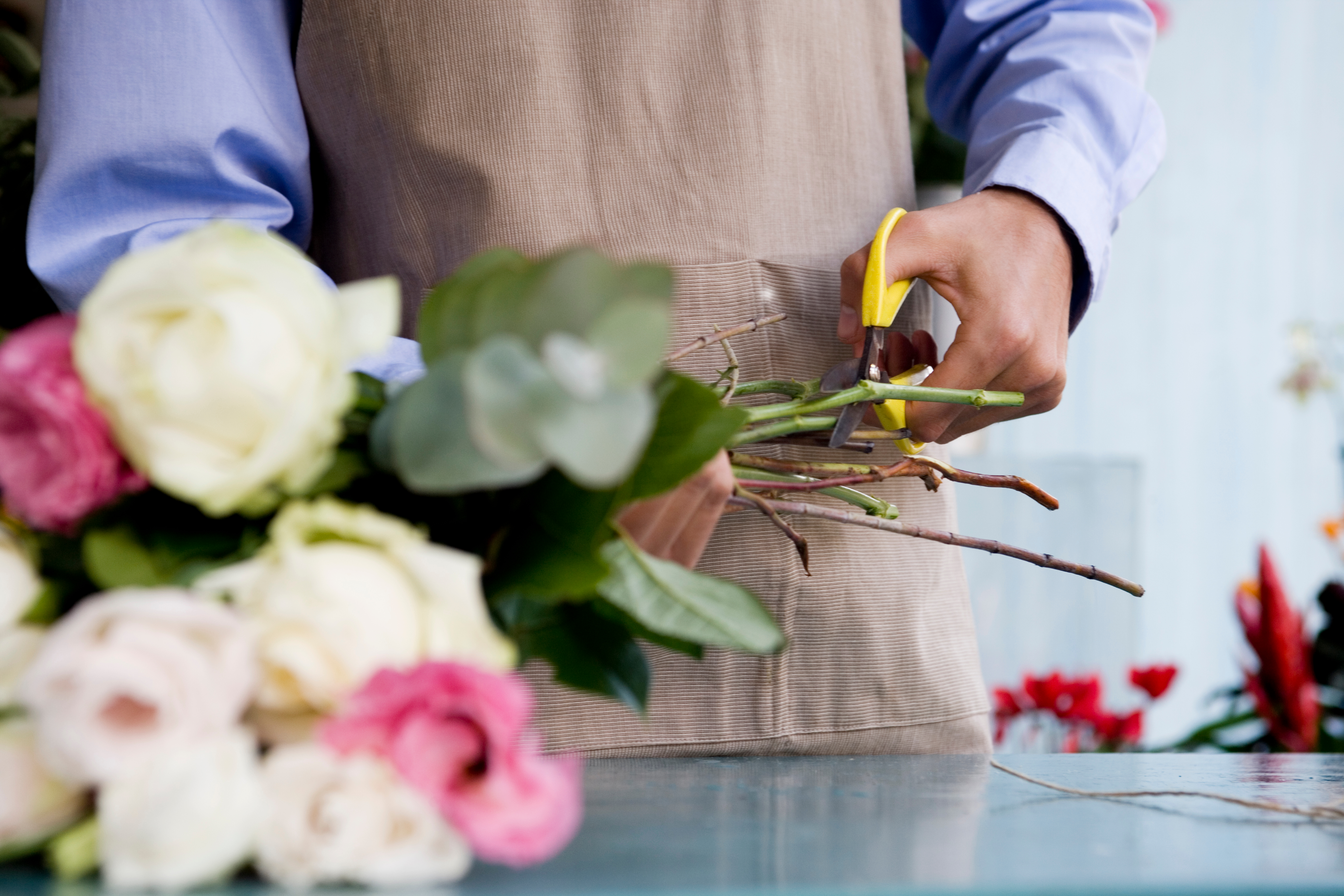 Florist bei der Arbeit mit Rosen in der Werkstatt